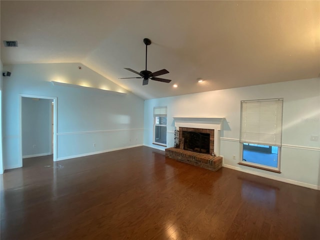 unfurnished living room with vaulted ceiling, dark wood-type flooring, ceiling fan, and a brick fireplace