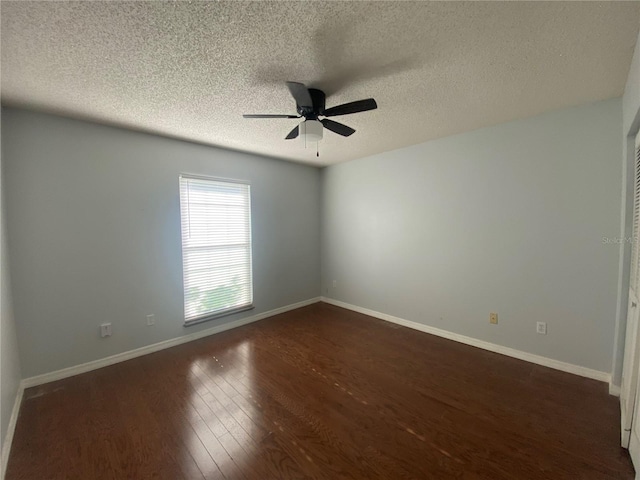 spare room with a textured ceiling, ceiling fan, and dark hardwood / wood-style flooring