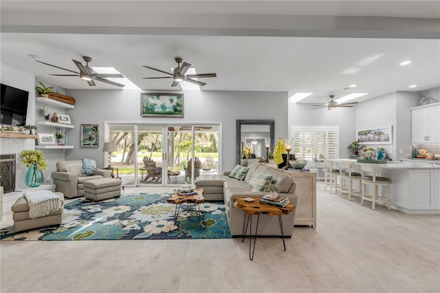 living room with ceiling fan, light hardwood / wood-style flooring, and a healthy amount of sunlight