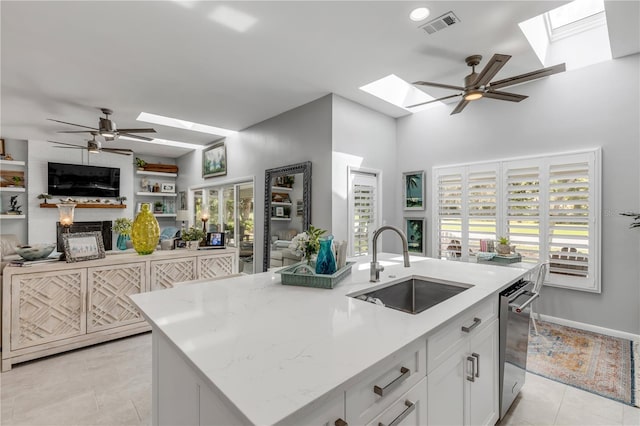 kitchen with white cabinets, sink, an island with sink, and a wealth of natural light