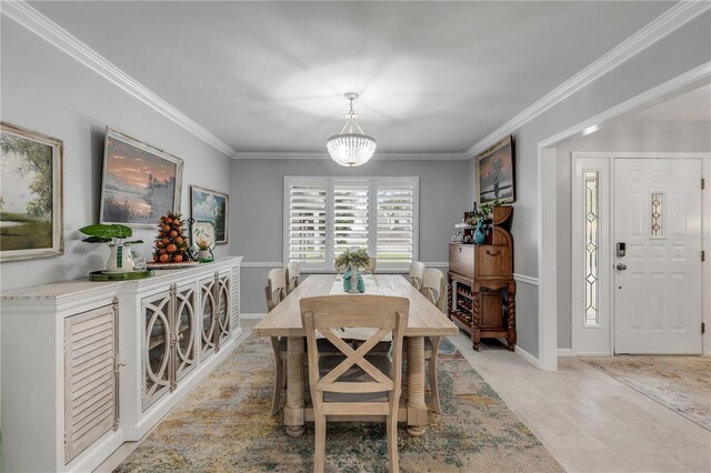 dining space with ornamental molding and a chandelier