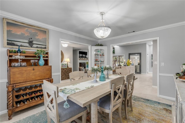 dining space featuring ornamental molding and an inviting chandelier