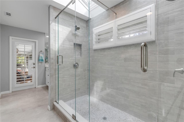 bathroom with a skylight and a shower with door