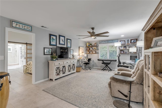 living room featuring a barn door, light tile patterned flooring, and ceiling fan