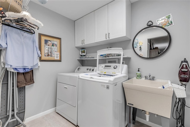 clothes washing area with light tile patterned floors, separate washer and dryer, cabinets, and sink