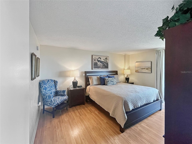 bedroom featuring a textured ceiling and wood-type flooring