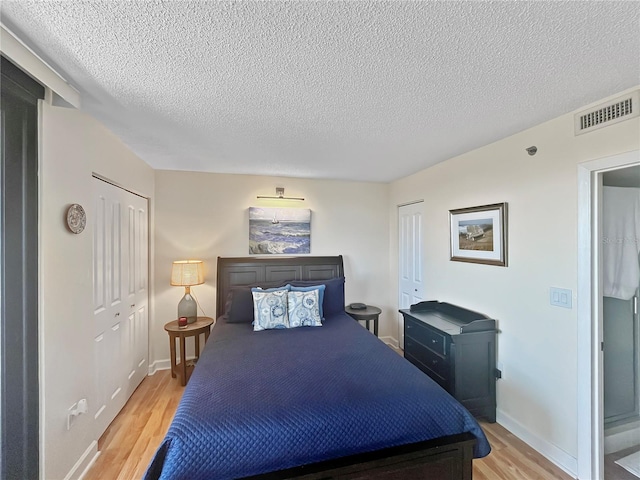 bedroom with light hardwood / wood-style flooring and a textured ceiling