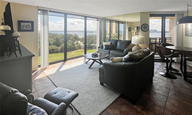 tiled living room with a healthy amount of sunlight, a water view, and expansive windows