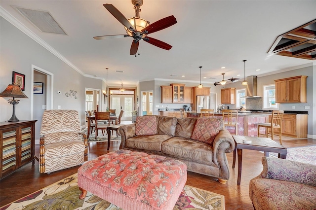 living room featuring ornamental molding, ceiling fan, dark hardwood / wood-style floors, and a healthy amount of sunlight