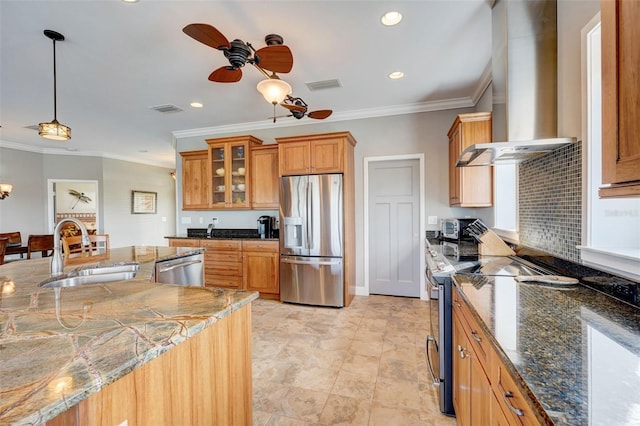 kitchen featuring sink, hanging light fixtures, wall chimney exhaust hood, stainless steel appliances, and ceiling fan