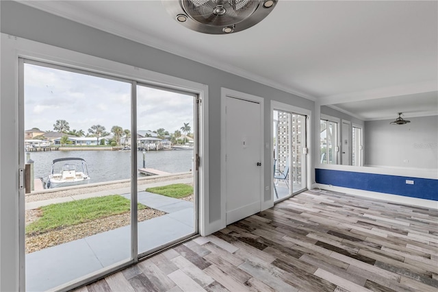 entryway with light hardwood / wood-style flooring, a water view, ceiling fan, and crown molding