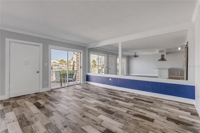 unfurnished living room featuring wood-type flooring, crown molding, and ceiling fan