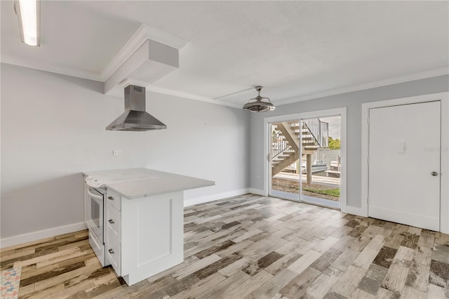 interior space with light stone countertops, white cabinets, light hardwood / wood-style floors, and wall chimney range hood