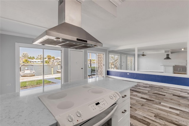 kitchen with white cabinetry, wall chimney exhaust hood, light hardwood / wood-style flooring, ceiling fan, and white electric range