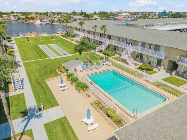 view of pool with a lawn, a water view, and a patio area