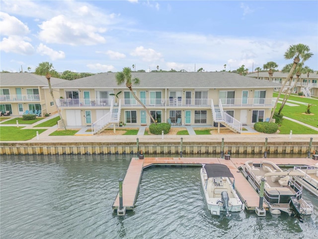 view of swimming pool with a boat dock, a lawn, and a water view