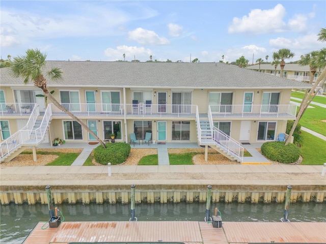 rear view of house featuring a balcony, a patio, and a water view