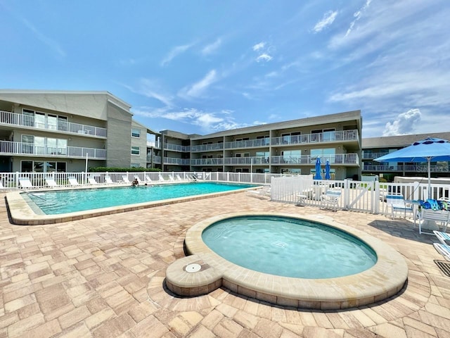 view of swimming pool with a patio and a community hot tub