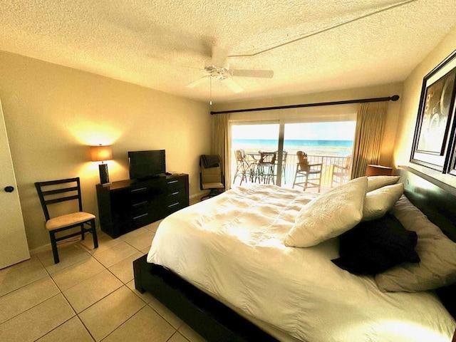 bedroom with light tile patterned floors, a textured ceiling, access to exterior, and ceiling fan