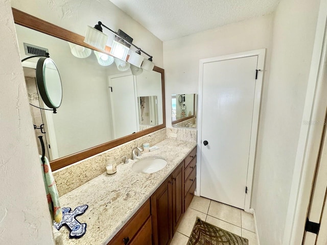 bathroom featuring tile patterned floors, a textured ceiling, and vanity