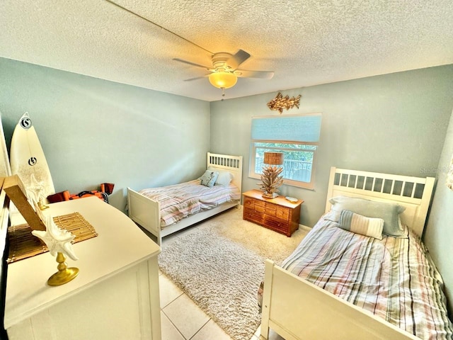 bedroom with ceiling fan, a textured ceiling, and light tile patterned floors