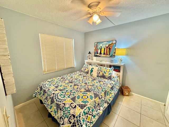 tiled bedroom with ceiling fan and a textured ceiling