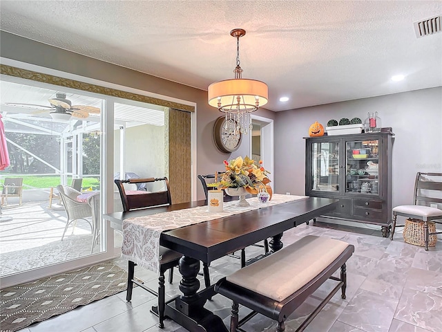 dining space featuring a textured ceiling and ceiling fan