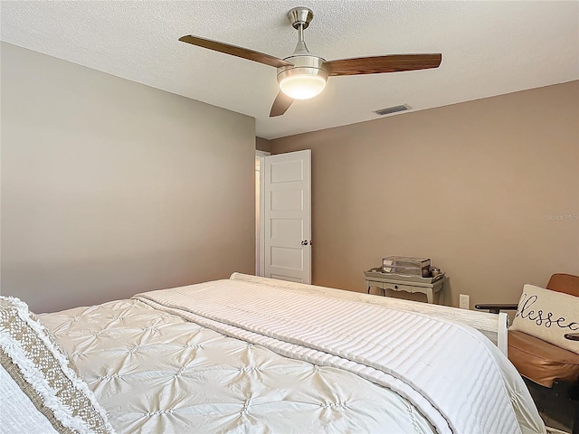 bedroom with ceiling fan and a textured ceiling