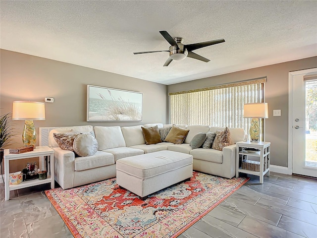 living room featuring a textured ceiling and ceiling fan