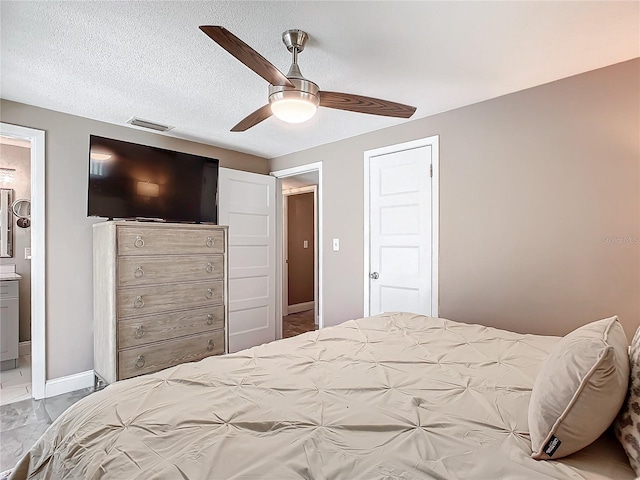 bedroom featuring connected bathroom, ceiling fan, and a textured ceiling