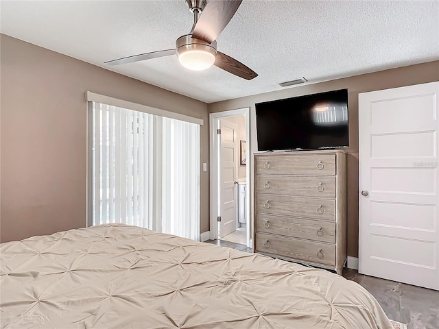 bedroom featuring ceiling fan, a textured ceiling, and connected bathroom