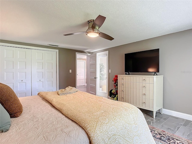 bedroom with a textured ceiling, a closet, and ceiling fan