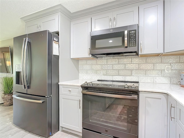 kitchen featuring white cabinets, stainless steel appliances, and tasteful backsplash