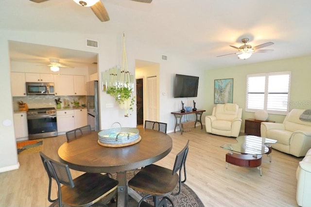 dining room with light hardwood / wood-style floors and ceiling fan