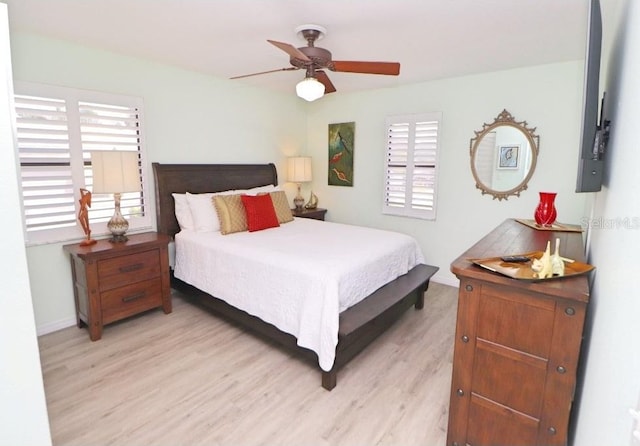 bedroom featuring multiple windows, light wood-type flooring, and ceiling fan