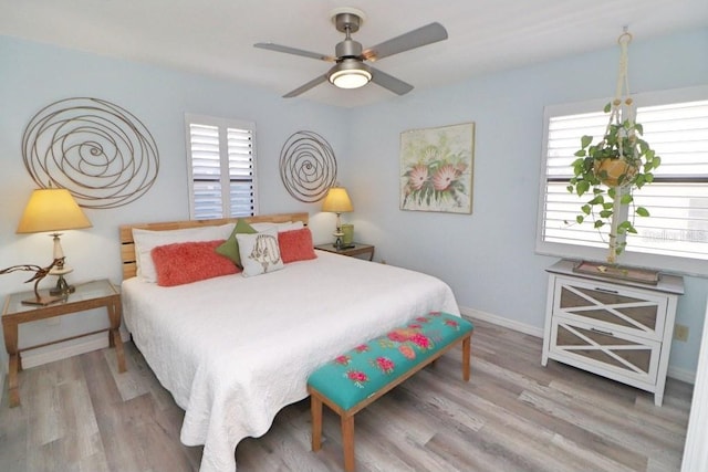 bedroom featuring light hardwood / wood-style flooring, multiple windows, and ceiling fan