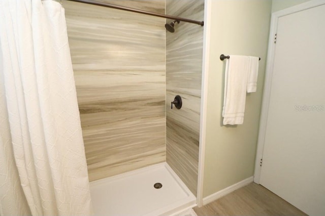 bathroom featuring wood-type flooring and a shower with curtain