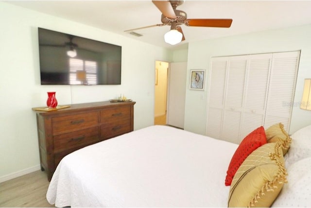 bedroom featuring light wood-type flooring, a closet, and ceiling fan