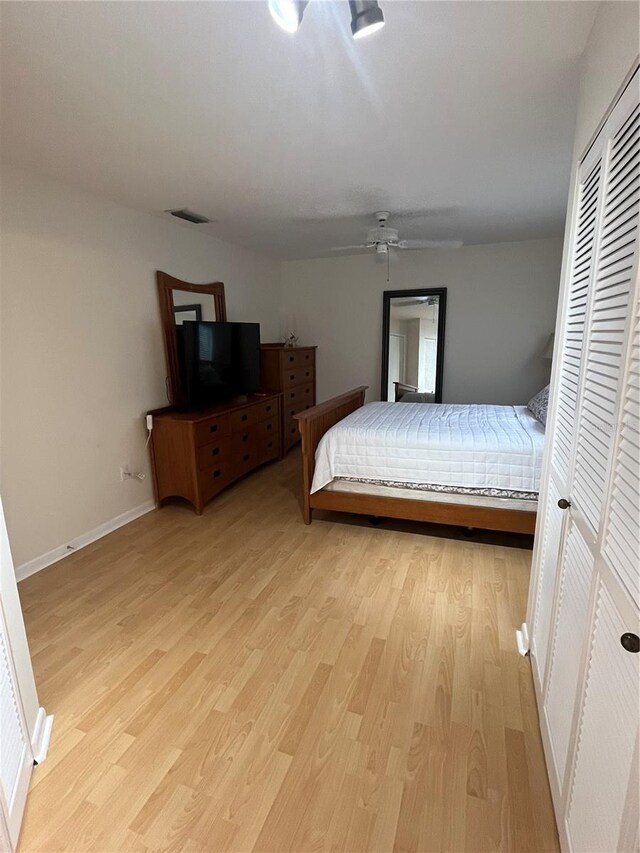 bedroom with a closet, light wood-type flooring, and ceiling fan