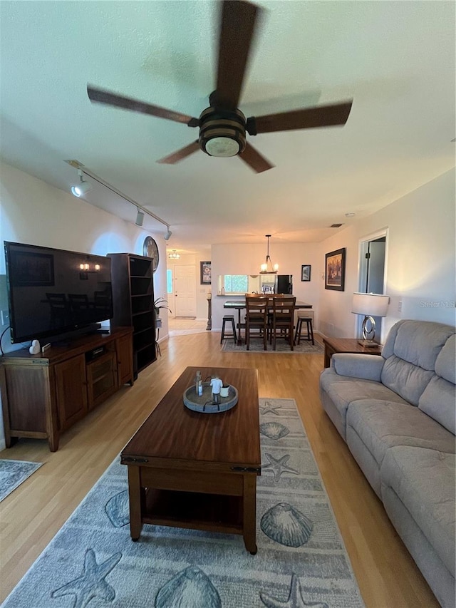 living room featuring ceiling fan, light hardwood / wood-style floors, and track lighting