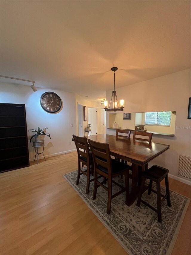 dining space featuring an inviting chandelier and light hardwood / wood-style flooring