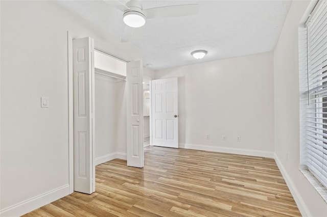 unfurnished bedroom featuring a textured ceiling, light hardwood / wood-style floors, ceiling fan, and a closet