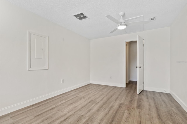 unfurnished room with ceiling fan, a textured ceiling, light hardwood / wood-style floors, and electric panel