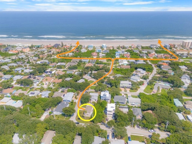 drone / aerial view featuring a water view and a view of the beach