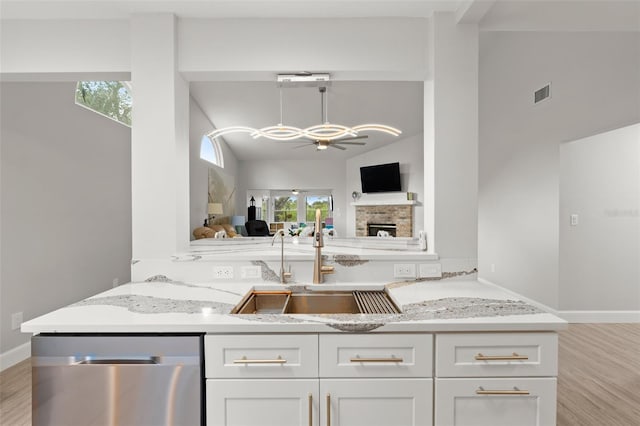 kitchen with kitchen peninsula, a healthy amount of sunlight, and stainless steel dishwasher