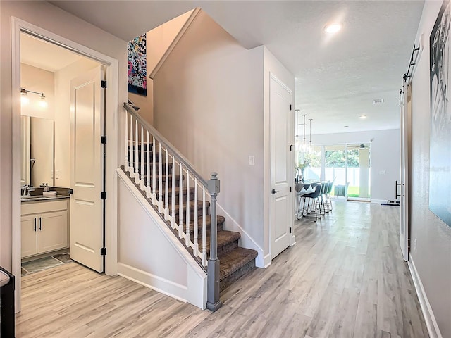 stairway featuring hardwood / wood-style flooring and sink