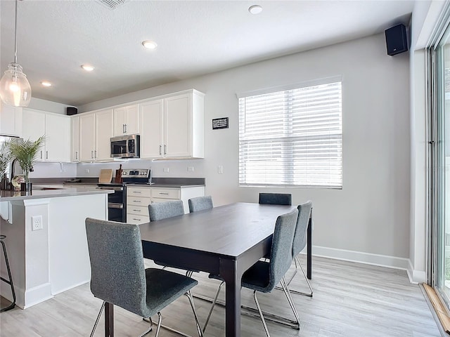 dining space featuring light wood-type flooring and a wealth of natural light