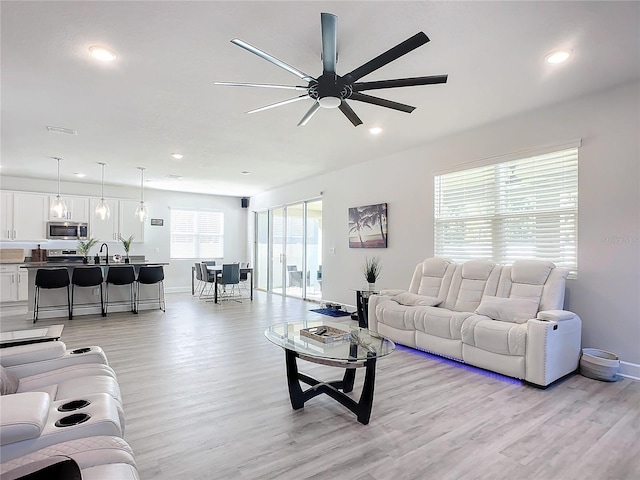 living room with ceiling fan, a healthy amount of sunlight, and light hardwood / wood-style floors