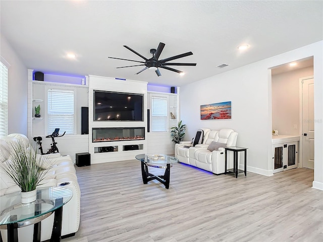 living room with ceiling fan and light hardwood / wood-style floors