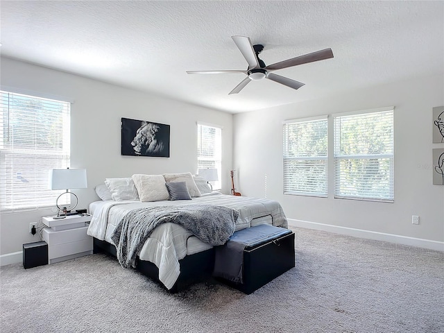 carpeted bedroom featuring a textured ceiling and ceiling fan